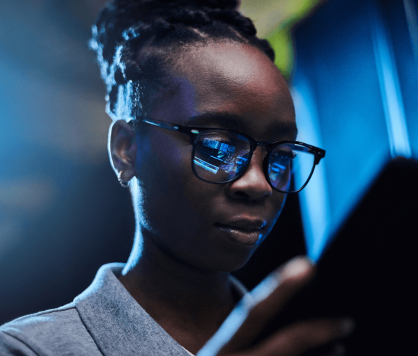 Mobile device lights reflecting off of a woman's glasses